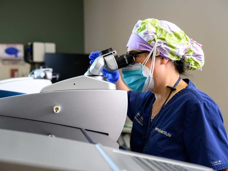 A student with the School of Dentistry examines a patients mouth during a clinical training session.