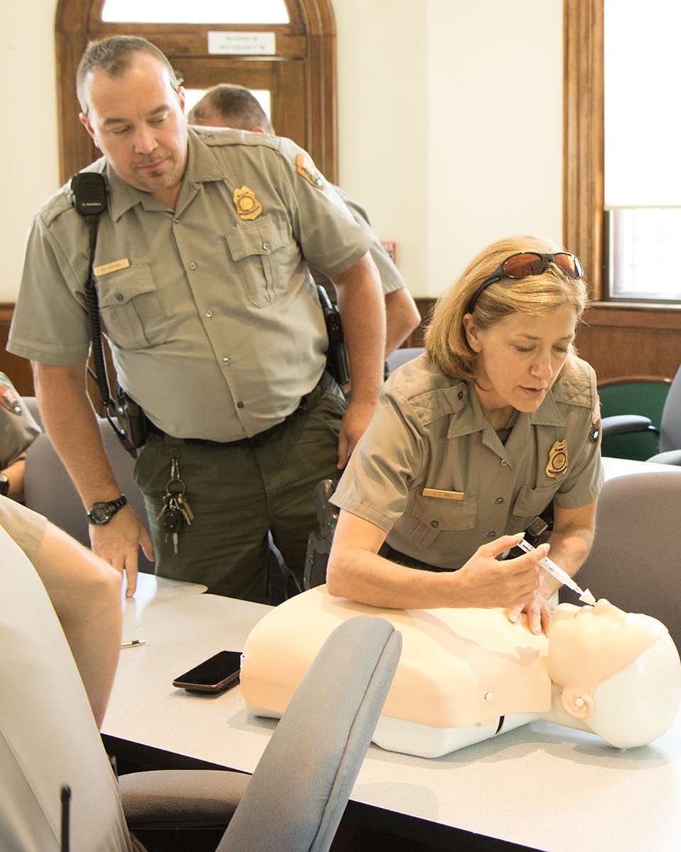 New River Gorge National Park Service rangers practice administering intranasal naloxone using a saline solution during a training session.